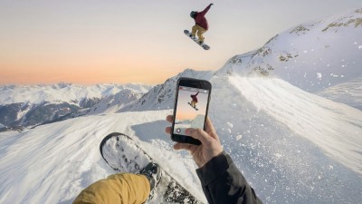 Man snowboarding with smart phone