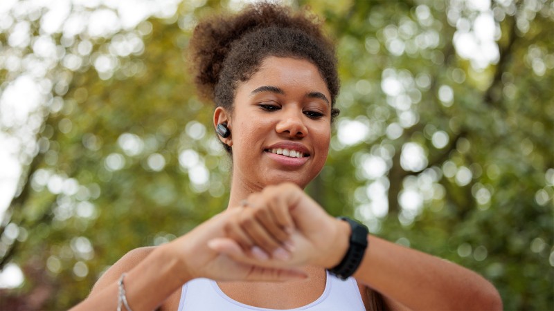 A woman watching her watch while walking